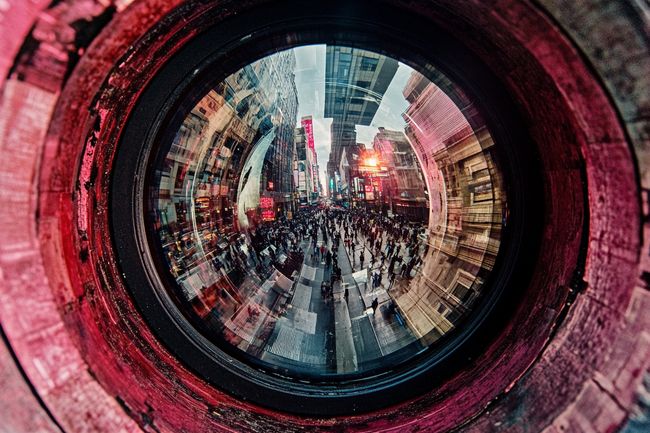 A close-up of a dusty, weathered security camera lens reflecting a distorted, glitch-like image of a crowded urban street, symbolizing AI surveillance and its ethical flaws.